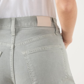 Model wearing Paige Arellia Ankle Wide-Leg Jeans in Vintage Seaglass, close-up of rear pocket, belt loops, and logo patch detail.