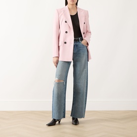 Model wearing Paige Wide Leg Jeans in Terazzo Deconstructed, ripped knee detail, styled with pink blazer and black heels.