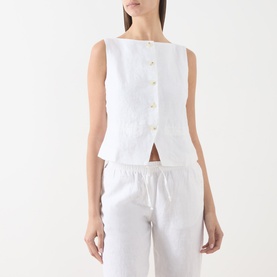 Model wearing Samsoe & Samsoe white linen blouse with back button detail, styled with matching white linen wide-leg trousers.