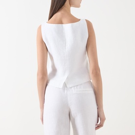 Model wearing Samsoe & Samsoe white linen blouse, back view, styled with matching white trousers.