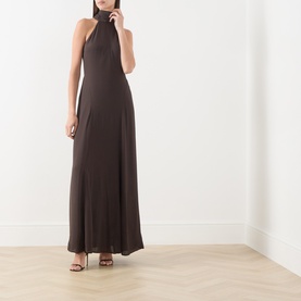 Model wearing Samsoe & Samsoe mulch halterneck maxi dress in viscose, with open back and fluid drape, styled with black heeled sandals.