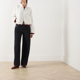 Model wearing Samsoe & Samsoe egret cotton jacket with burgundy trim, styled with dark wide-leg jeans and burgundy shoes.
