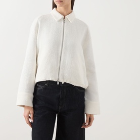 Model wearing Samsoe & Samsoe egret jacket with zip front, wide sleeves and cropped hem, styled with black jeans.