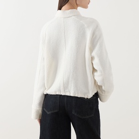 Model wearing Samsoe & Samsoe Egret jacket, back view, with dark denim jeans. Fluffy cotton-blend knit texture with ribbed hem.