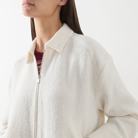 Model wearing Samsoe & Samsoe Egret fleece jacket with zip fastening, styled with a striped burgundy top underneath. Close-up detail shot.