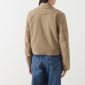 Model wearing Samsoe & Samsoe Sakit Double-Breasted Jacket in Lead Gray, rear view, showing locker loop detail, styled with blue wide-leg jeans
