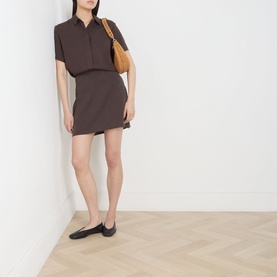 Model wearing Samsoe & Samsoe Mina Fluid Shirt in Mulch, styled with a mini skirt, tan shoulder bag and black flat shoes