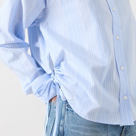 Model wearing Samsoe & Samsoe Sarita Striped Shirt in Windsurfer St, close-up of side tie fastening detail, styled with blue jeans