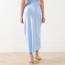Model wearing Samsoe & Samsoe skirt in Windsurfer blue with diagonal textured stripe detail, styled with gold strappy heeled mules.