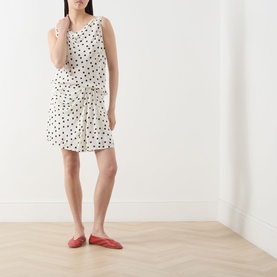 Model wearing Samsoe & Samsoe Saiben Polka Dot Skirt in Drifting Dots Egret, mini length with draped detail, styled with red ballet flats