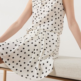 Model wearing Samsoe & Samsoe Saiben Polka Dot Skirt in Drifting Dots Egret with asymmetric hemline and draped details