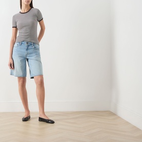 Model wearing Samsoe & Samsoe mulch stripe fitted T-shirt with contrast rib trim, styled with light wash denim shorts and black flats.