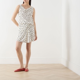 Model wearing Samsoe & Samsoe Sapoppy Polka Dot Top in Drifting Dots Egret with matching shorts and red flat shoes
