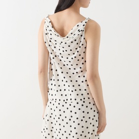 Model wearing Samsoe & Samsoe Sapoppy Polka Dot Top in Drifting Dots Egret, showing draped cowl back neckline, sleeveless, polka dot pattern.