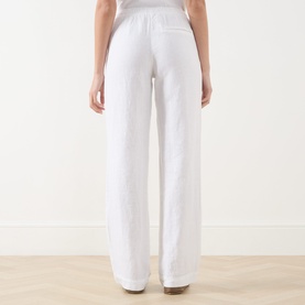 Model wearing Samsoe & Samsoe white wide-leg linen trousers, rear view, styled with a light grey top.