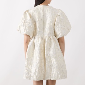 Model wearing Sister Jane Chalk Mini Dress in white jacquard, back view showing puff sleeves, elasticated cuffs and rear zip fastening