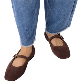 Model wearing Whistles brown suede Mary Jane flat shoes with buckle strap, styled with frayed-hem blue jeans.