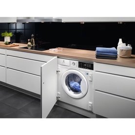 Electrolux Built In Washing Machine 8kg 1400 RPM in white, integrated into modern kitchen cabinetry with wooden worktop