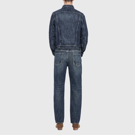 Model wearing All Saints dark indigo denim jacket, shown from behind, styled with matching dark indigo jeans.
