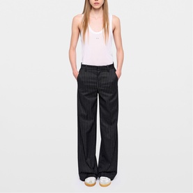 Model wearing Zadig grey pinstripe wide-leg trousers with white sleeveless top. Full-length relaxed fit with side pockets.