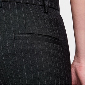 Model wearing Zadig grey pinstripe tailored trousers, close-up of back pocket and waistband detail