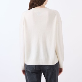 Model wearing Anine Bing Lee Cashmere Sweater in cream, back view, with dropped shoulders and ribbed trims, styled with grey jeans.