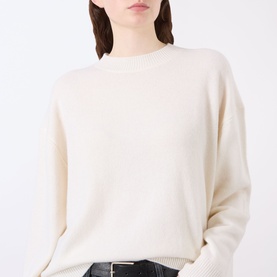 Model wearing Anine Bing Lee Cashmere Sweater in cream with crew neck, dropped shoulders, and ribbed trims, styled with black belt.