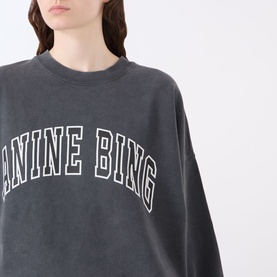 Model wearing Anine Bing Miles Logo Sweatshirt in Washed Black with white arch logo print, round neckline and ribbed trims.