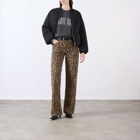 Model wearing Anine Bing Miles Logo Sweatshirt in Washed Black with leopard print wide-leg trousers and black loafers.