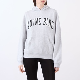 Model wearing Anine Bing Harvey New Classic Hoodie in grey melange with black logo print, kangaroo pocket, styled with black leggings.