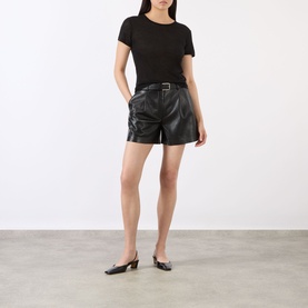 Model wearing Anine Bing black lyocell-wool T-shirt with black leather belted shorts and black slingback flats.