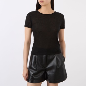 Model wearing Anine Bing black short-sleeve knit top, styled with black leather high-waisted shorts.