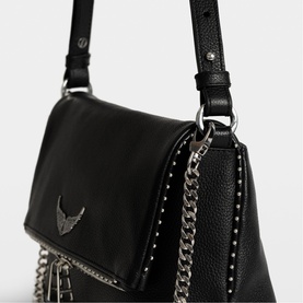 Zadig black leather crossbody bag with silver stud trim, chain detail, and winged logo hardware on flap closure.