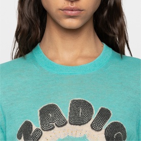 Model wearing Zadig green crew neck T-shirt with crystal embellished graphic lettering, close-up detail shot
