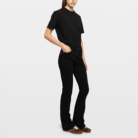 Model wearing black short-sleeve polo top and black flared jeans, styled with Zadig brown shoes with leopard-print detail.