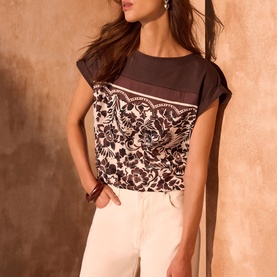 Model wearing brown and cream floral print cap sleeve top, styled with white wide-leg trousers