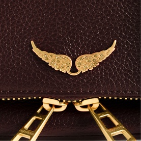 Zadig purple leather bag close-up showing gold wing charm embellishment and gold chain strap detail.