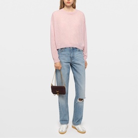 Model carrying Zadig purple shoulder bag with gold-tone hardware, styled with pink knit top and light-wash distressed jeans
