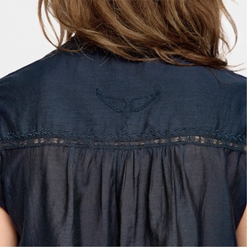 Model wearing Zadig blue womenswear top, back view showing embroidered wing detail and lace trim insert on sheer fabric yoke