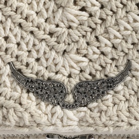 Zadig white chunky knit clutch bag with silver crystal embellished angel wings brooch detail, close-up texture shot.