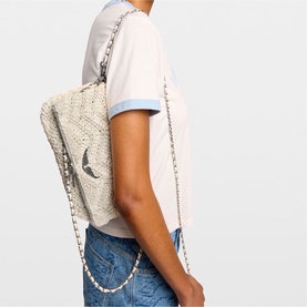 Model carrying Zadig white woven raffia backpack with silver-tone chain straps, styled with light blue jeans and white T-shirt