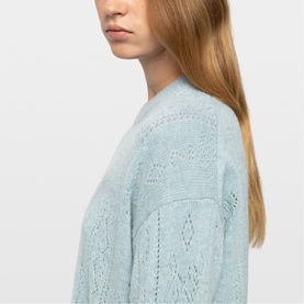Model wearing Zadig blue open-knit pointelle sweater, close-up detail of textured stitch pattern on shoulder and sleeve