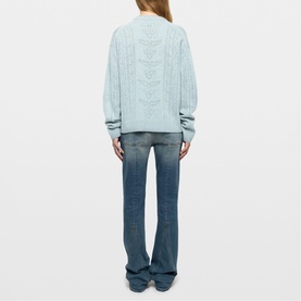Model wearing Zadig blue cable-knit sweater, rear view, styled with mid-wash flared jeans.