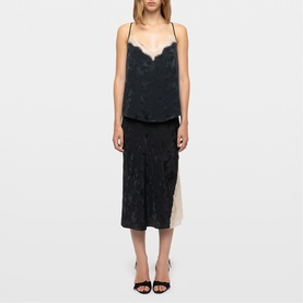 Model wearing Zadig green satin slip dress with lace trim neckline and side split, styled with black heeled mules.