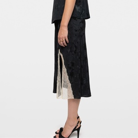 Model wearing Zadig green midi skirt with lace panel insert detail, styled with matching top and black heeled sandals