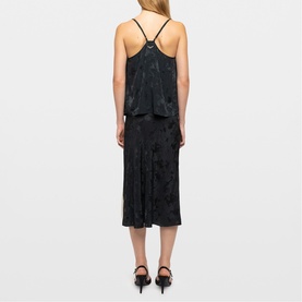 Model wearing Zadig Womens French Dress in green, dark floral jacquard fabric, spaghetti straps, styled with black heels, rear view.
