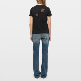 Model wearing Zadig green T-shirt with star print on back, styled with mid-blue flared jeans, rear view