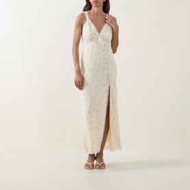 Model wearing LOVESHACKFANCY Lemon Haze floral maxi dress with V-neckline, lace trim, and front split, styled with strappy sandals.