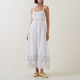 Model wearing LOVESHACKFANCY Optic White cotton maxi dress with floral embroidery, square neck, thin straps, and tiered skirt with border detail.