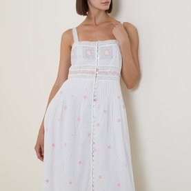Model wearing LOVESHACKFANCY Optic White cotton midi dress with lace trim, crochet bodice, button-front placket and pink floral embroidery.